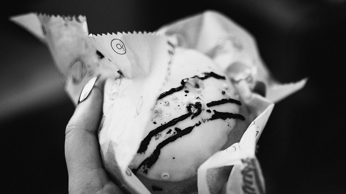 woman holding donut in wrapper