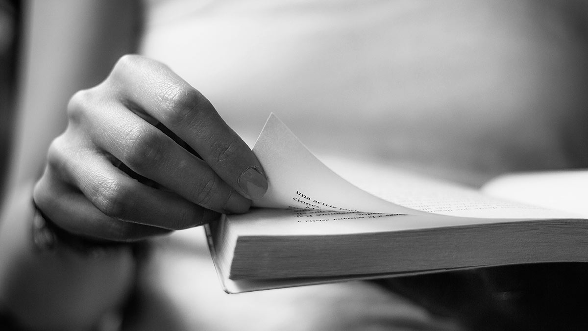 woman flipping page of book