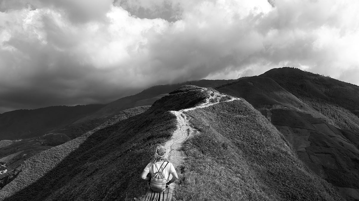 young woman hiking along mountain ridge